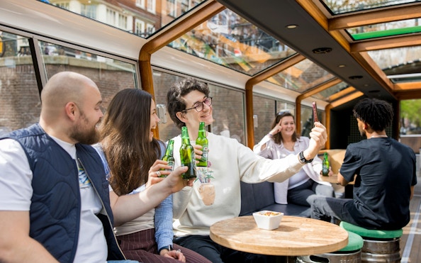 Group enjoying Heineken beers on a canal cruise, Amsterdam.
