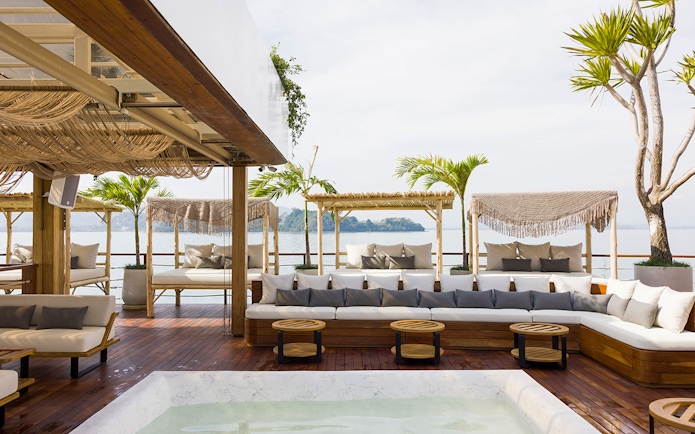 Sunset terrace at Yona Beach Club in Phuket with ocean view and lounge seating.