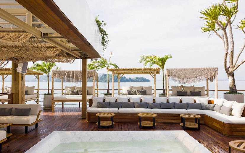 Sunset terrace at Yona Beach Club in Phuket with ocean view and lounge seating.
