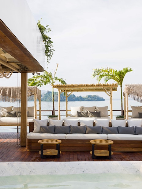 Sunset terrace at Yona Beach Club in Phuket with ocean view and lounge seating.