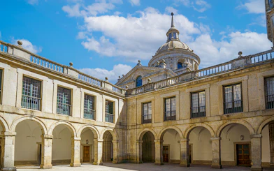 Courtyard of the Royal Monastery of San Lorenzo del Escorial with arched walkways.