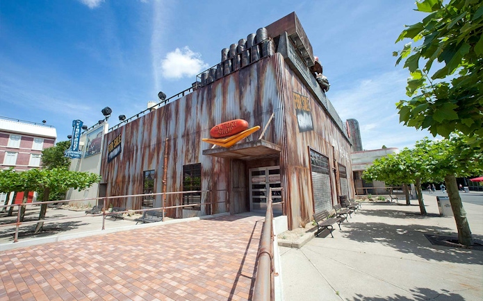 Van Helsing's Factory entrance at Movie Park with industrial facade and trees nearby.