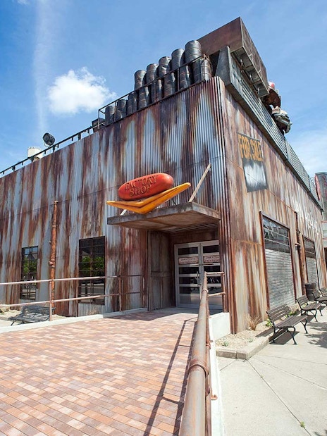 Van Helsing's Factory entrance at Movie Park with industrial facade and trees nearby.