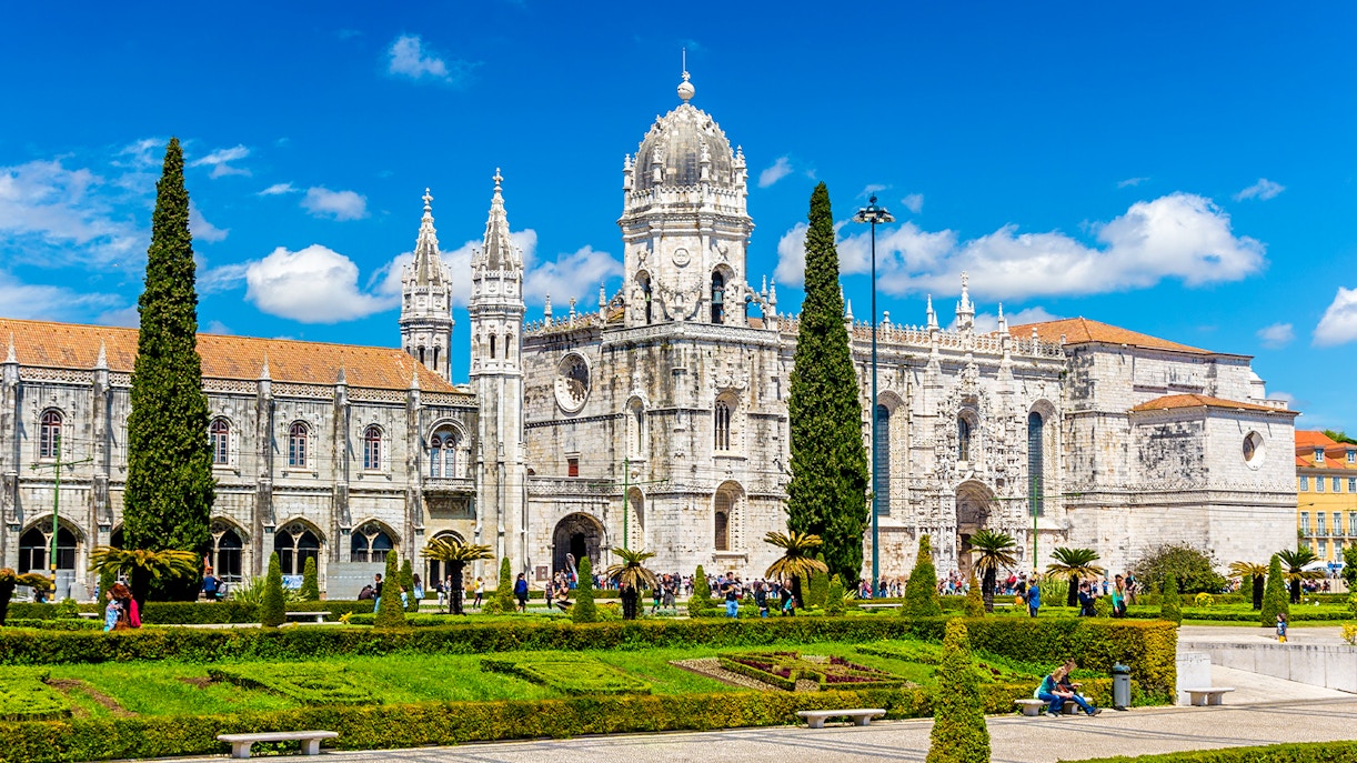 Monastery of Jerónimos in Lisbon with ornate architecture and manicured gardens.