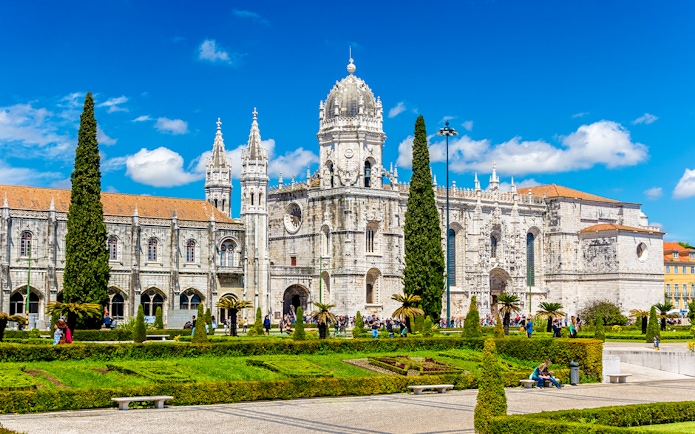 Monastery of Jerónimos in Lisbon with ornate architecture and manicured gardens.
