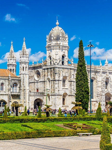 Monastery of Jerónimos in Lisbon with ornate architecture and manicured gardens.