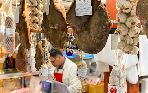 Hanging cured meats and garlic at a local market in Florence.
