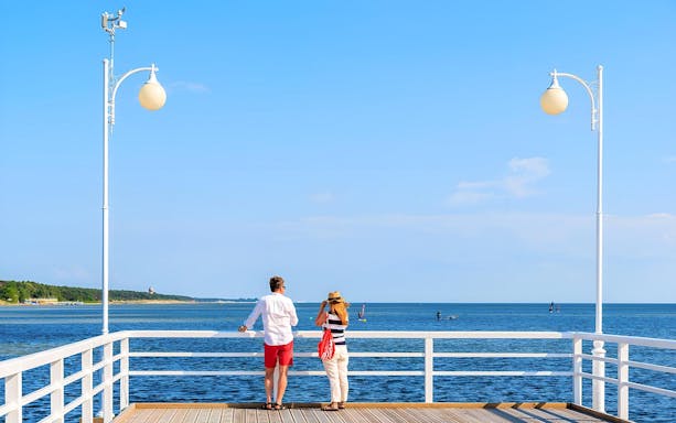 Couple enjoying the view from a pier in Sopot during a guided tour.