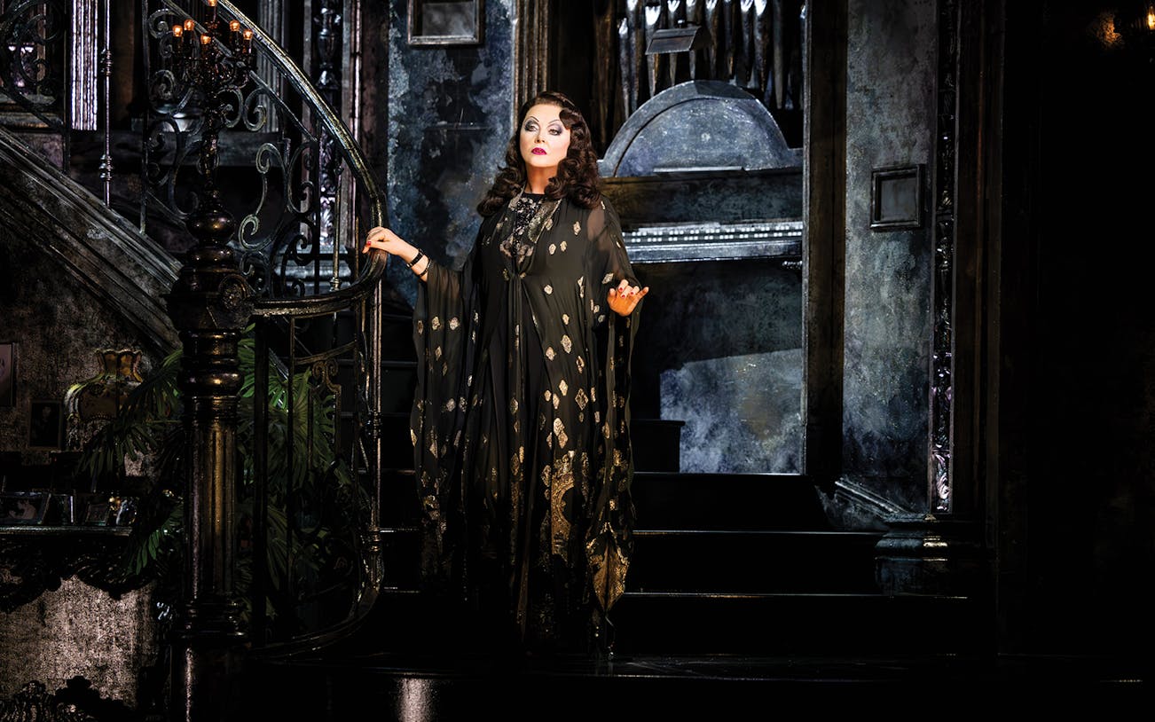 Performer on ornate staircase in Sunset Boulevard theater production.