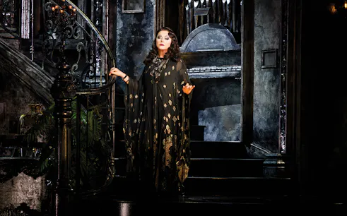 Performer on ornate staircase in Sunset Boulevard theater production.