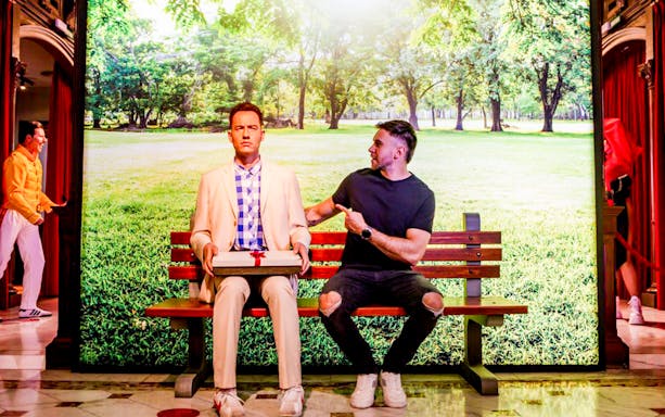 Man interacting with a wax figure on a bench at Barcelona Wax Museum during VIP tour.