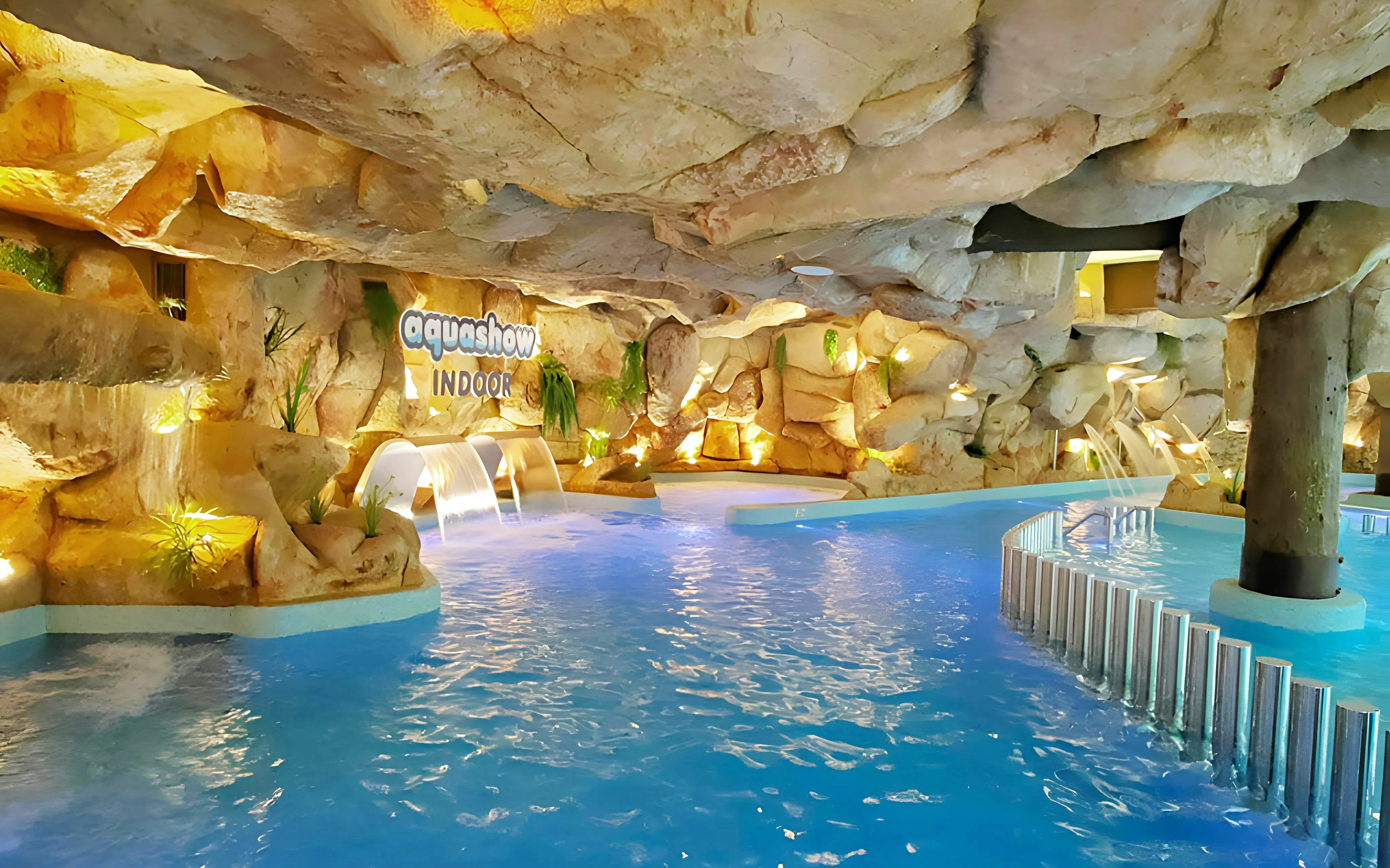 Aquashow Indoor Park water feature with rock formations and cascading waterfalls.