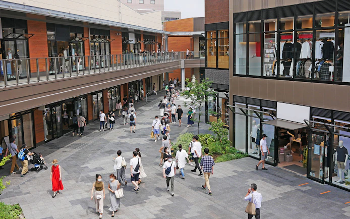 Shoppers walking through a modern shopping area near Okinawa Monorail.