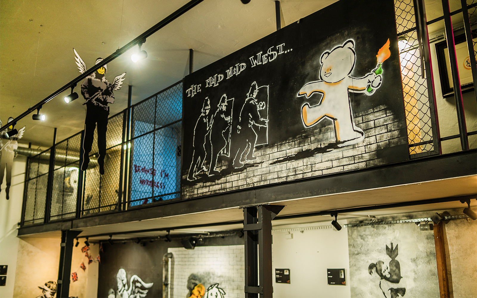 Street art exhibit at Banksy Museum in Krakow featuring a bear with a Molotov cocktail.