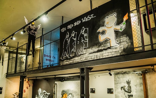 Street art exhibit at Banksy Museum in Krakow featuring a bear with a Molotov cocktail.