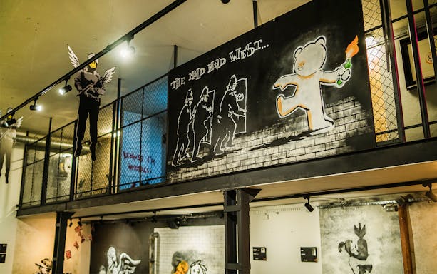 Street art exhibit at Banksy Museum in Krakow featuring a bear with a Molotov cocktail.