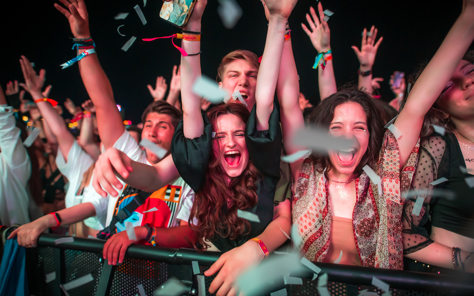 Crowd enjoying a lively event with confetti in the air.