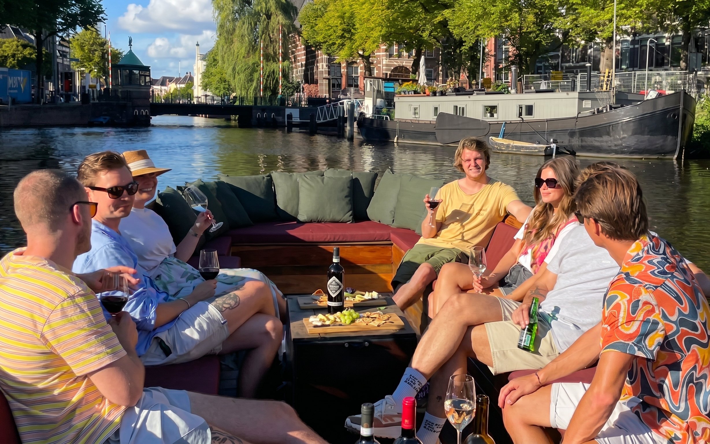 Group enjoying wine on a boat during Groningen historical canal cruise.