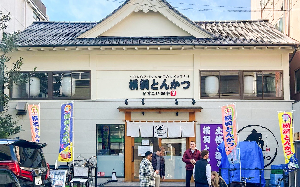 Sumo show entry at Yokozuna Tonkatsu restaurant in Japan.