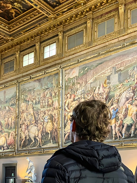 Tourists viewing frescoes inside Palazzo Vecchio, Florence.