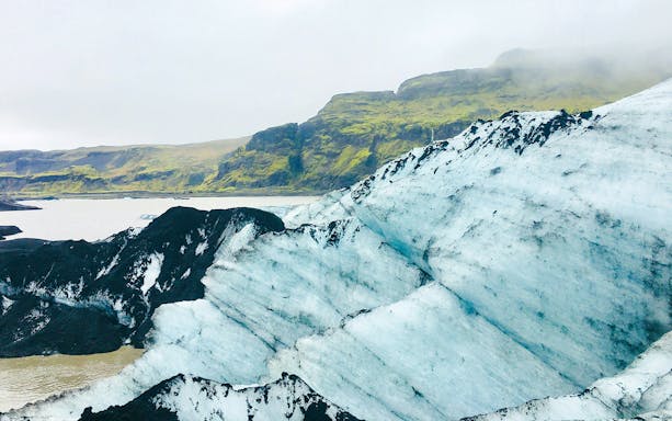 Solheimajökull Glacier with surrounding moss-covered hills in Iceland.