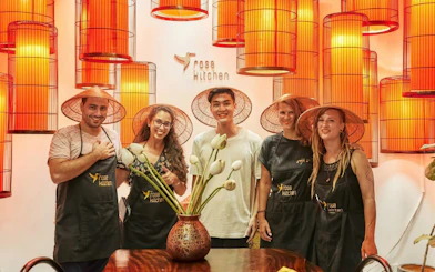 Participants in conical hats at a Vietnamese cooking class in Rose Kitchen, Hanoi.