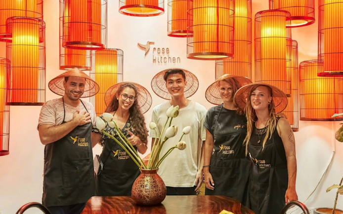 Participants in conical hats at a Vietnamese cooking class in Rose Kitchen, Hanoi.