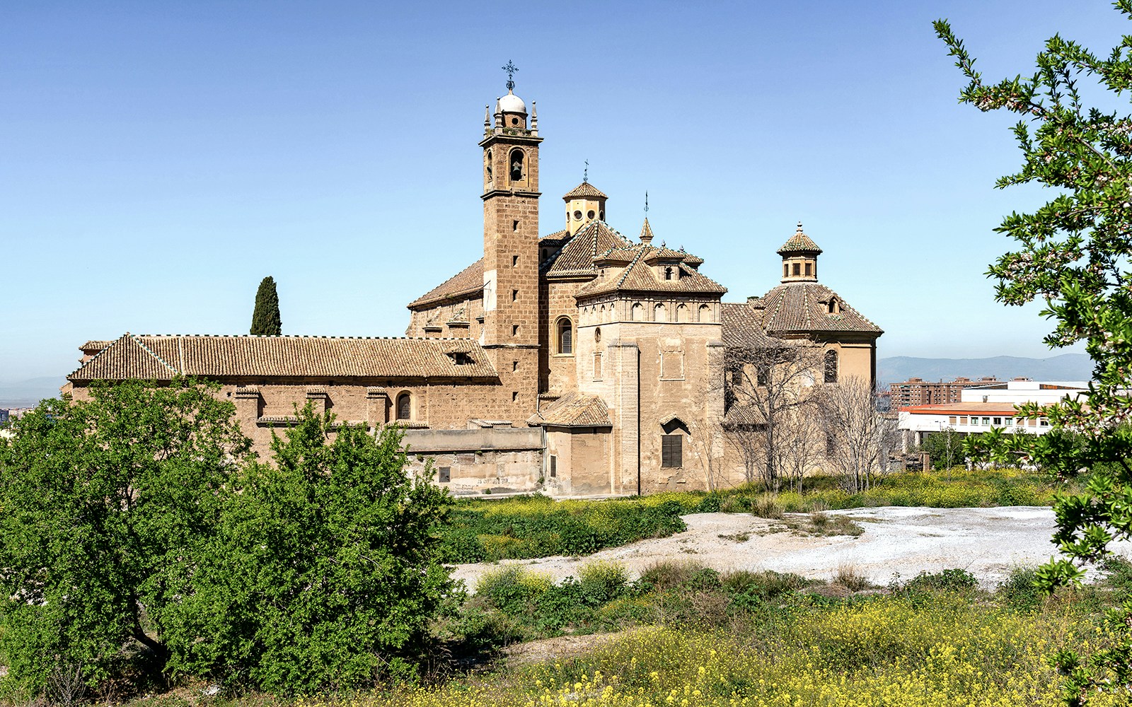 Granada church with historic architecture near Alhambra, surrounded by greenery.
