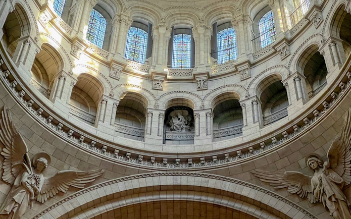 Interior view of Sacre Coeur dome with stained glass and angel sculptures, Montmartre, Paris.