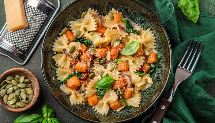 Farfalle pasta with pumpkin, spinach, and seeds on a plate, Moulin Rouge tour.