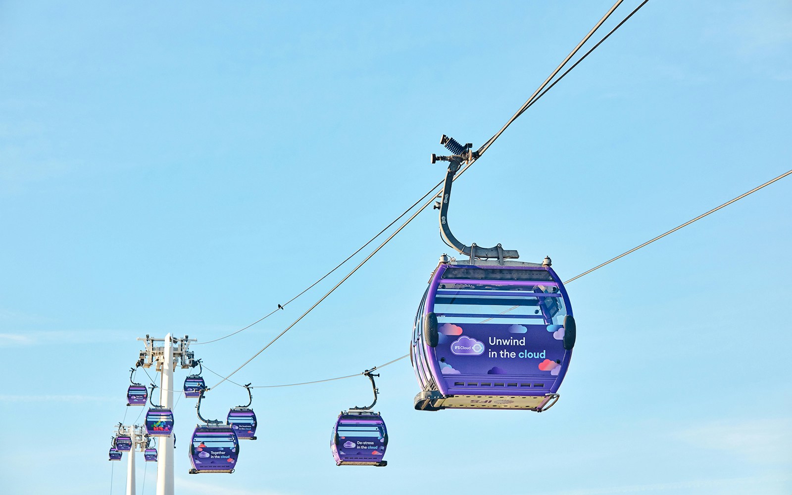IFS Cloud Cable Car in London against a clear blue sky.