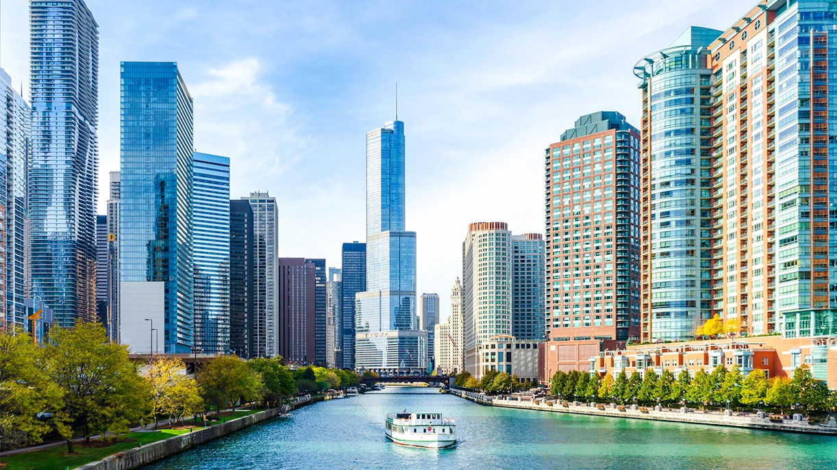 Chicago River cruise boat with tourists viewing Lake Michigan skyline.
