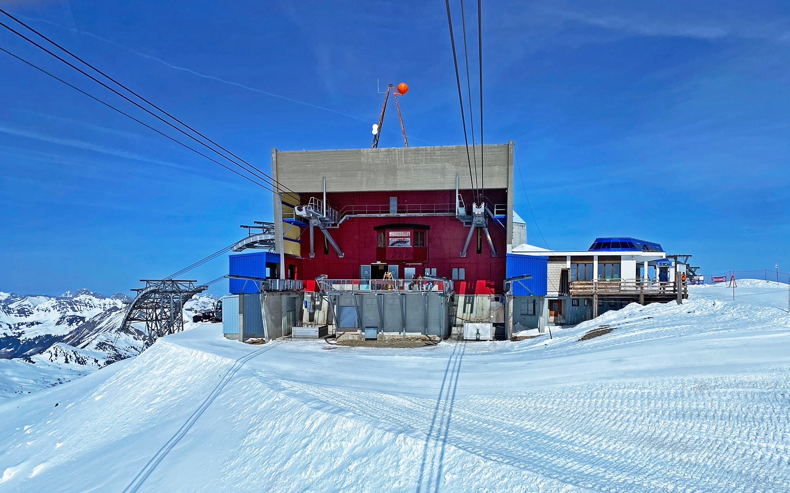 Eine rote Seilbahnstation in den verschneiten Schweizer Alpen