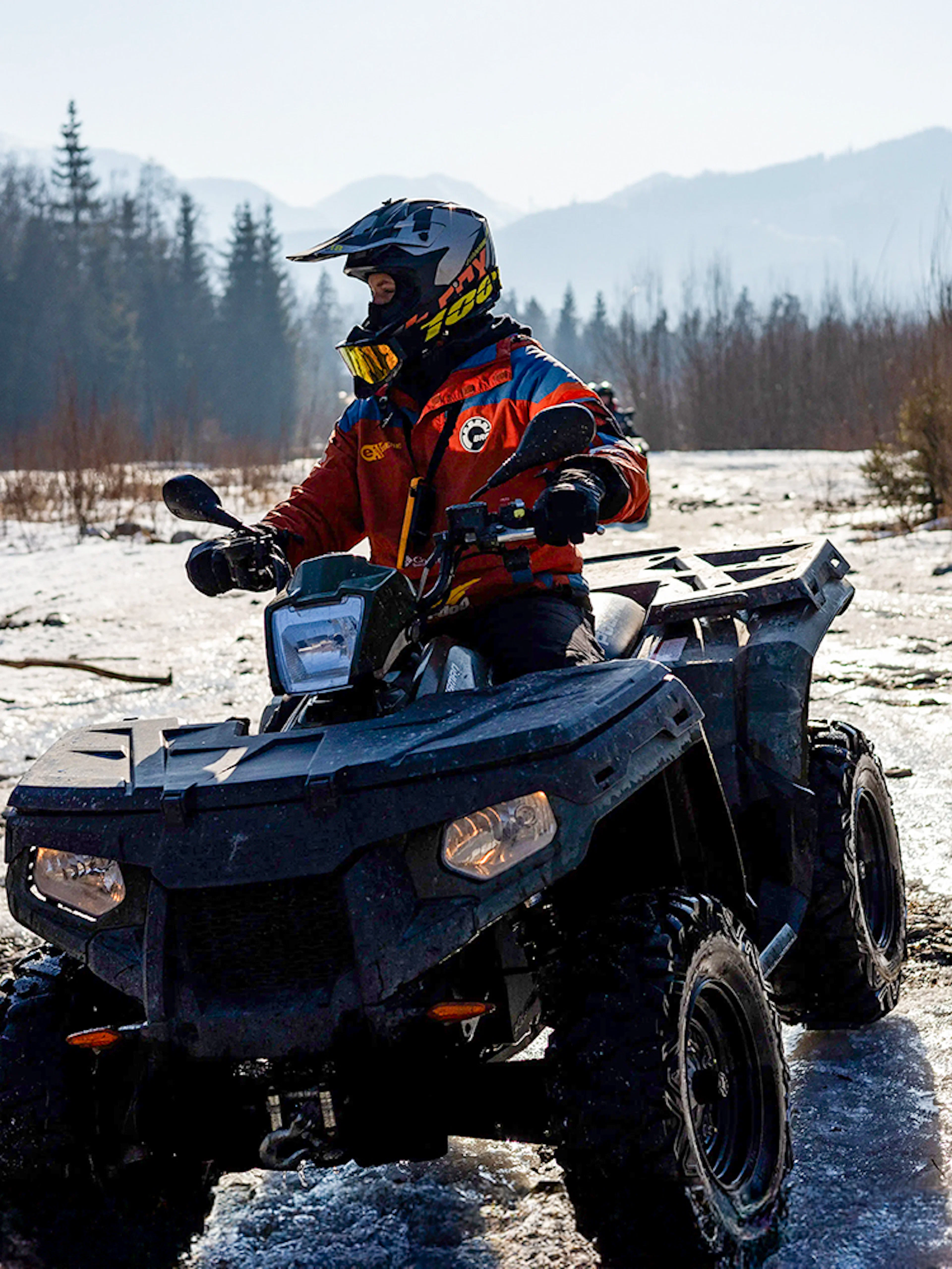 Guest riding ATV on snowy terrain in Zakopane during quad biking adventure.