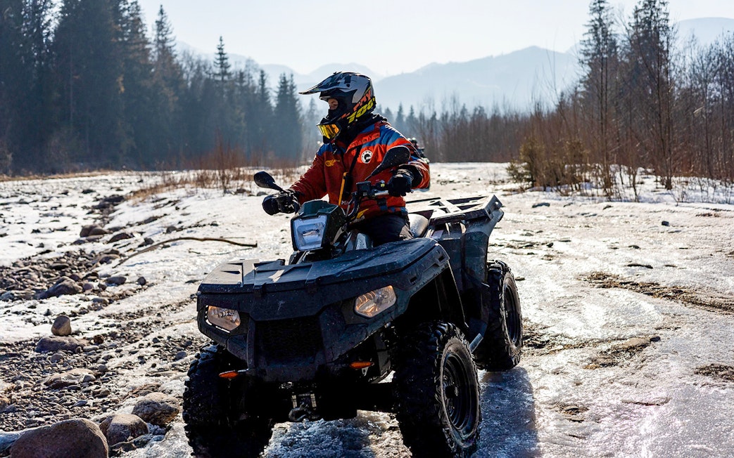 Guest riding ATV on snowy terrain in Zakopane during quad biking adventure.