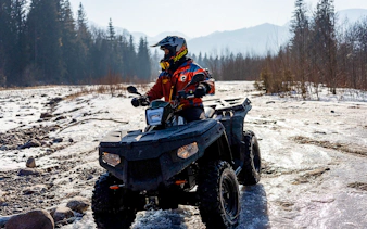 Guest riding ATV on snowy terrain in Zakopane during quad biking adventure.