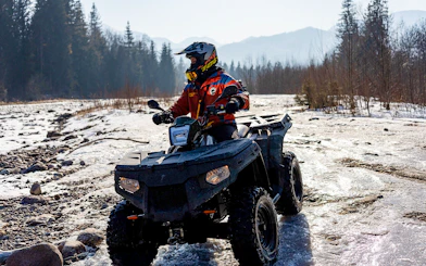 Guest riding ATV on snowy terrain in Zakopane during quad biking adventure.