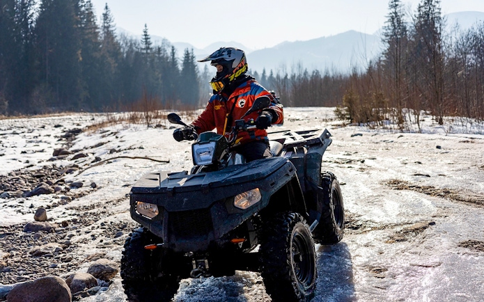 Guest riding ATV on snowy terrain in Zakopane during quad biking adventure.