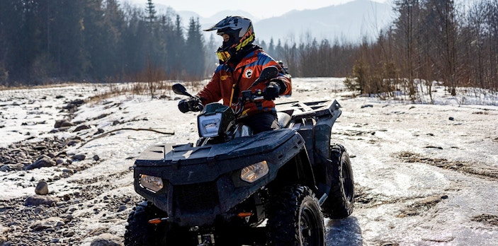 Guest riding ATV on snowy terrain in Zakopane during quad biking adventure.