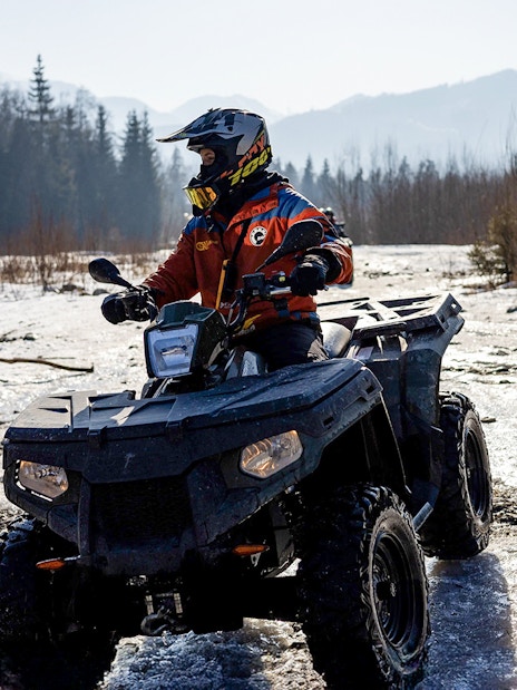 Guest riding ATV on snowy terrain in Zakopane during quad biking adventure.