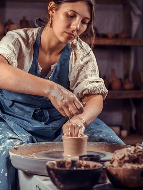 Pottery workshop participant shaping clay on a wheel in Cappadocia.