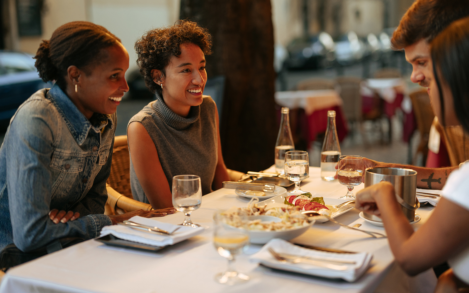 Tourists dining at an outdoor restaurant in Rome, enjoying a meal together.