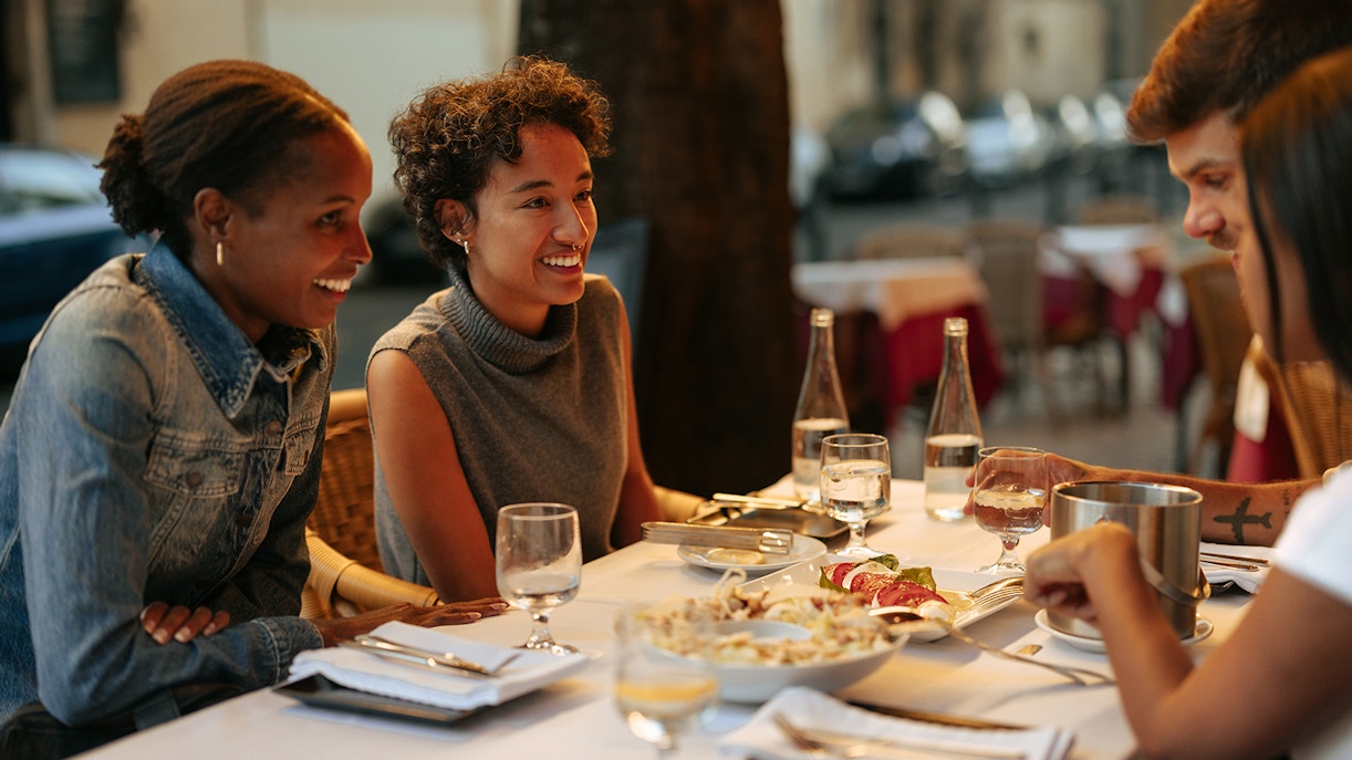 Tourists dining at an outdoor restaurant in Rome, enjoying a meal together.