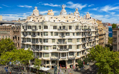 Casa Mila rooftop with unique chimneys in Barcelona, showcasing Gaudi's architectural design.