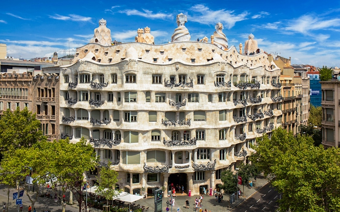 Casa Mila rooftop with unique chimneys in Barcelona, showcasing Gaudi's architectural design.