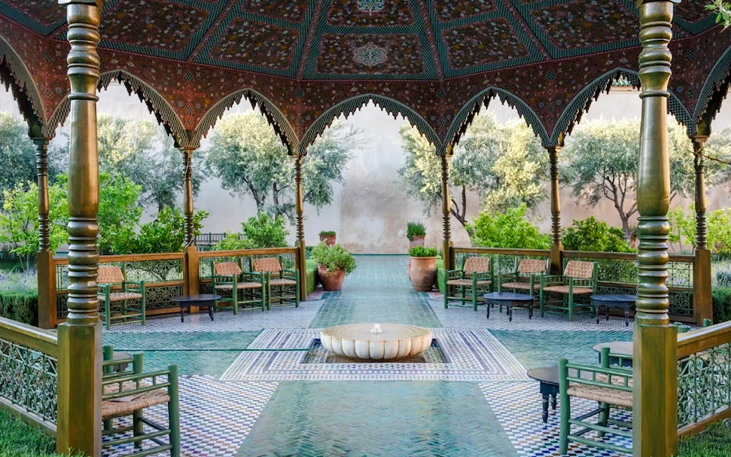 Le Jardin Secret courtyard with ornate arches and lush greenery in Marrakech, Morocco.