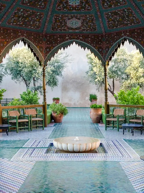 Le Jardin Secret courtyard with ornate arches and lush greenery in Marrakech, Morocco.