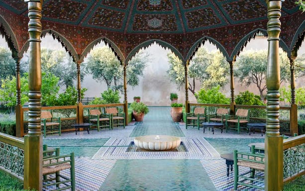 Le Jardin Secret courtyard with ornate arches and lush greenery in Marrakech, Morocco.