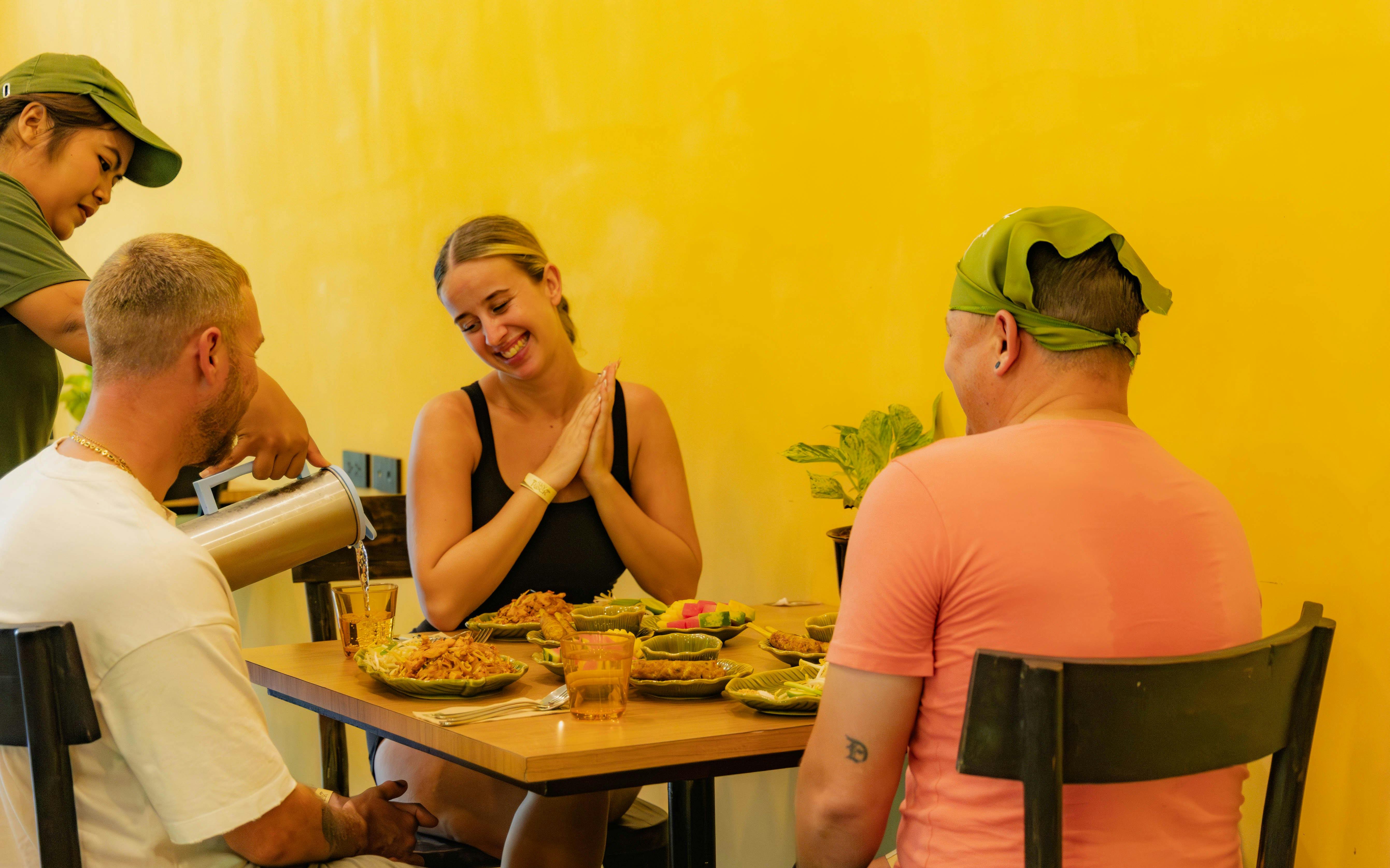 Dining experience at SKY ROCK Thailand with local dishes served at a vibrant yellow-walled restaurant.