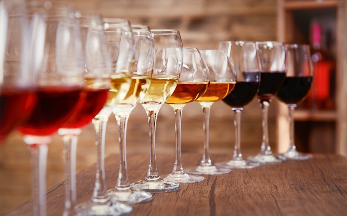 Wine glasses lined up on a wooden table, part of a Krka National Park tour from Split.